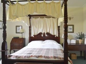 a bedroom with a four poster bed with a canopy at Old West Manse in Bridgend