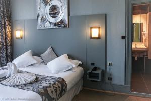 a hotel room with a bed and a bathroom at Hôtel Le Bristol Strasbourg Gare in Strasbourg