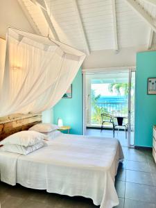 a bedroom with a bed with a mosquito net at Cannelle in Deshaies