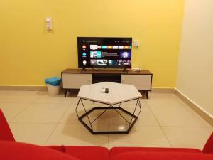 ein Wohnzimmer mit einem Couchtisch und einem TV in der Unterkunft HB1613- 2 bedroom-Apartment -Wifi -Netflix-Parking, 3040 in Cyberjaya