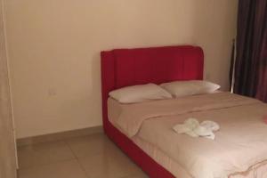 Bett mit rotem Kopfteil in einem Zimmer in der Unterkunft HB1613- 2 bedroom-Apartment -Wifi -Netflix-Parking, 3040 in Cyberjaya