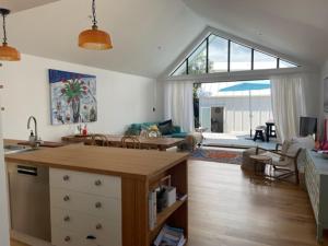 a kitchen and living room with a large window at The Lighthouse - Boathouse Bay in Auckland