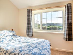 a bedroom with a bed and a window at Hafod in Llanengan