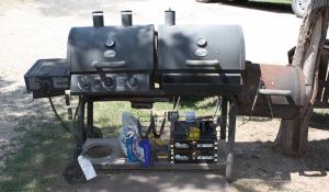 un grand grill installé au sol à côté d'un arbre dans l'établissement River Run Park Model Cabin on Guadalupe, à Kerrville