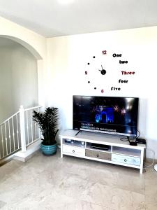 Televízia a/alebo spoločenská miestnosť v ubytovaní Elegant Palm Mar Apartment