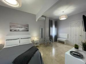 a bedroom with a large bed and a room with a table at Agradable Casa independiente con piscina in Seville