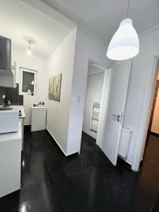 a kitchen with white walls and a black floor at Beautiful Studio With Private Yard in Athens