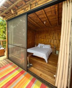 Habitación con cama en una terraza con ventana en Hakuna Matata Glamping timon, en Salento