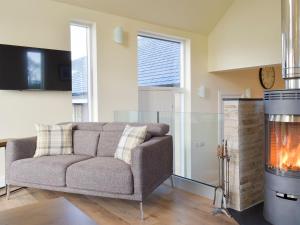 a living room with a couch and a fireplace at Falcon Cottage in Linlithgow