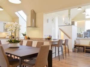 a dining room and kitchen with a table and chairs at Falcon Cottage in Linlithgow