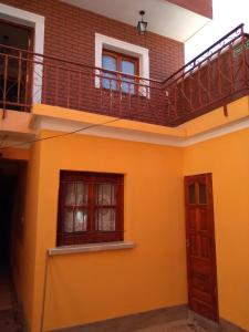 a house with a balcony and a staircase at HOSTAL DOÑA BERTA in Humahuaca