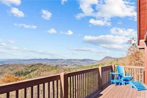 two blue chairs on a deck with a view of mountains at Luxury Mountain Cabin Retreat w/ Stunning Views in Bostic