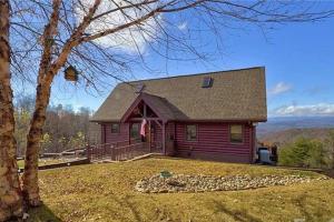 a red house with a tree in the yard at Luxury Mountain Cabin Retreat w/ Stunning Views in Bostic