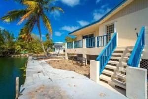 una casa en el agua con una palmera en Boater's Dream House on the water 150' of Sea Wall, en Big Pine Key