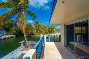una casa con una palmera junto al agua en Boater's Dream House on the water 150' of Sea Wall, en Big Pine Key