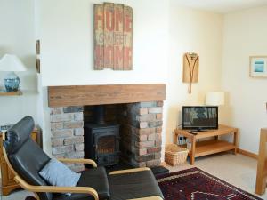 sala de estar con chimenea, sofá y TV en Fairfield en Ackergill