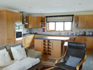 a kitchen with a couch and a chair in it at Fairfield in Ackergill