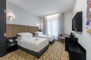 een hotelkamer met 2 bedden en een televisie bij HAKO HOTEL JBCC in Johor Bahru