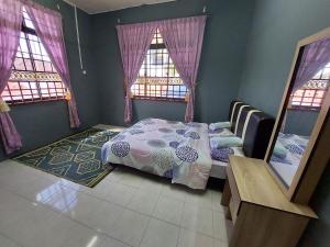 um quarto com uma cama e duas janelas em Jerai Geopark Cottage 3 bedrooms -Pulau Bunting em Yan
