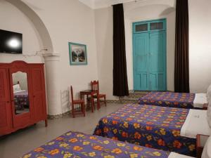 a hotel room with two beds and a blue door at HOTEL LIMÓN in Xalapa