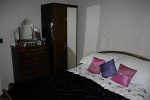 a bedroom with a bed with pink and purple pillows at Peel Cottage, Dilwyn in Dilwyn