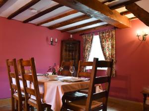 una mesa en un comedor con una pared rosa en The Cottage, en Great Blakenham