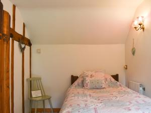 a bedroom with a bed and a chair at The Cottage in Great Blakenham