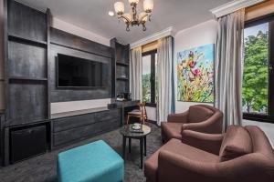 a living room with two chairs and a flat screen tv at HAKO HOTEL JBCC in Johor Bahru