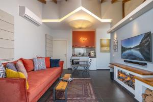 sala de estar con sofá rojo y chimenea en Yama Wine Spa and Suites, en Zikhron Ya‘aqov