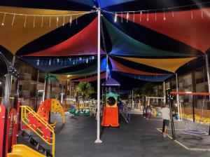 un parque infantil con una sombrilla grande en un edificio en Ondas Praia Resort, en Porto Seguro