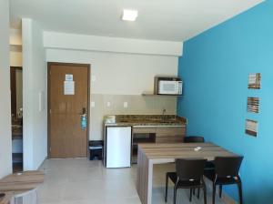 cocina con mesa, sillas y nevera en Ondas Praia Resort, en Porto Seguro