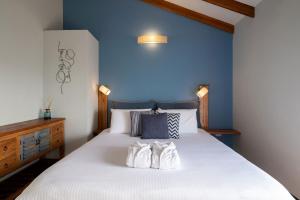 ein Schlafzimmer mit einem Bett mit zwei weißen Handtüchern darauf in der Unterkunft Yama Wine Spa and Suites in Zichron Ja’akow