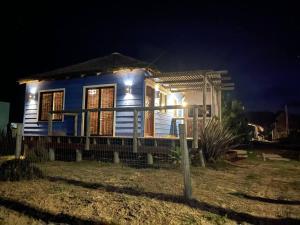 una pequeña casa azul por la noche con luces en Pléyades, en Punta del Diablo