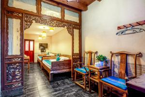 a bedroom with two beds and a mirror at Pingyao Baichanghong Inn in Pingyao