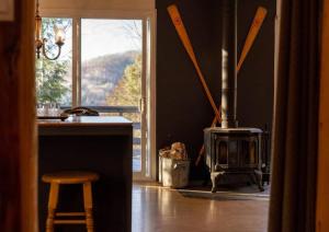 eine Küche mit einem Herd und einem Tisch mit einem Stuhl in der Unterkunft Cozy Lake Loj + Hot Tub & Fire Pit in Huberdeau