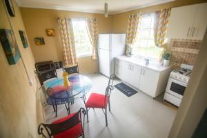 a small kitchen with a table and chairs in it at Fortescue Cherry Blossom Apartments in Saint Philip