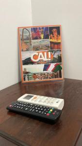 un mando a distancia sentado en una mesa al lado de una película en Confort 13-47, en Cali