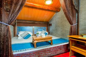 a bed in a room with a wooden ceiling at Pingyao Baichanghong Inn in Pingyao