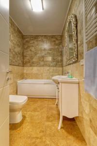 een badkamer met een toilet, een bad en een wastafel bij Luxurious 2 Bedroom Apartment in Herastrau in Boekarest