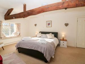 een slaapkamer met een groot bed met handdoeken erop bij Stone Wheel Cottage in Hook Norton +14 foto's