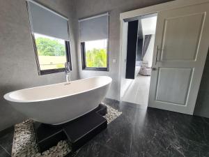 baño con una gran bañera blanca y una ventana en Villa Agrapana Lovina, en Lovina