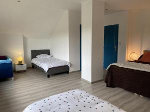 ein Schlafzimmer mit 2 Betten und einer blauen Tür in der Unterkunft Gîte Sauvagny, 3 pièces, 4 personnes - FR-1-489-430 in Sauvagny