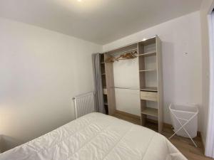 sypialnia z białym łóżkiem i szafą w obiekcie Beau studio cabine 4 pers, accès WiFi, pied de piste ! - FR-1-400-115 w mieście Eaux-Bonnes