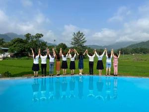 a group of people standing in front of a pool at Mai Chau Green house in Mai Châu