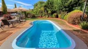 einen Pool im Garten mit Tisch und Stühlen in der Unterkunft Glider City Motel Benalla in Benalla