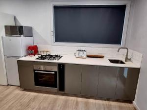 a kitchen with a sink and a stove and a refrigerator at Melazzano in Lilydale