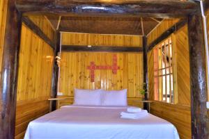 1 dormitorio con 1 cama en una habitación de madera en H'mong Eco House en Lao Cai