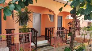 an orange house with a door and some plants at Mandurah's Inn, Malapascua in Malapascua Island