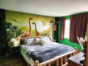a bedroom with a mural of dinosaurs on the wall at Jurassic Dino Suite Jiminy-Must See Sleeps 4 in Hancock