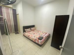ein kleines Schlafzimmer mit einem Bett in einem Zimmer in der Unterkunft Homestay Cikgu Muaz in Kuala Kangsar